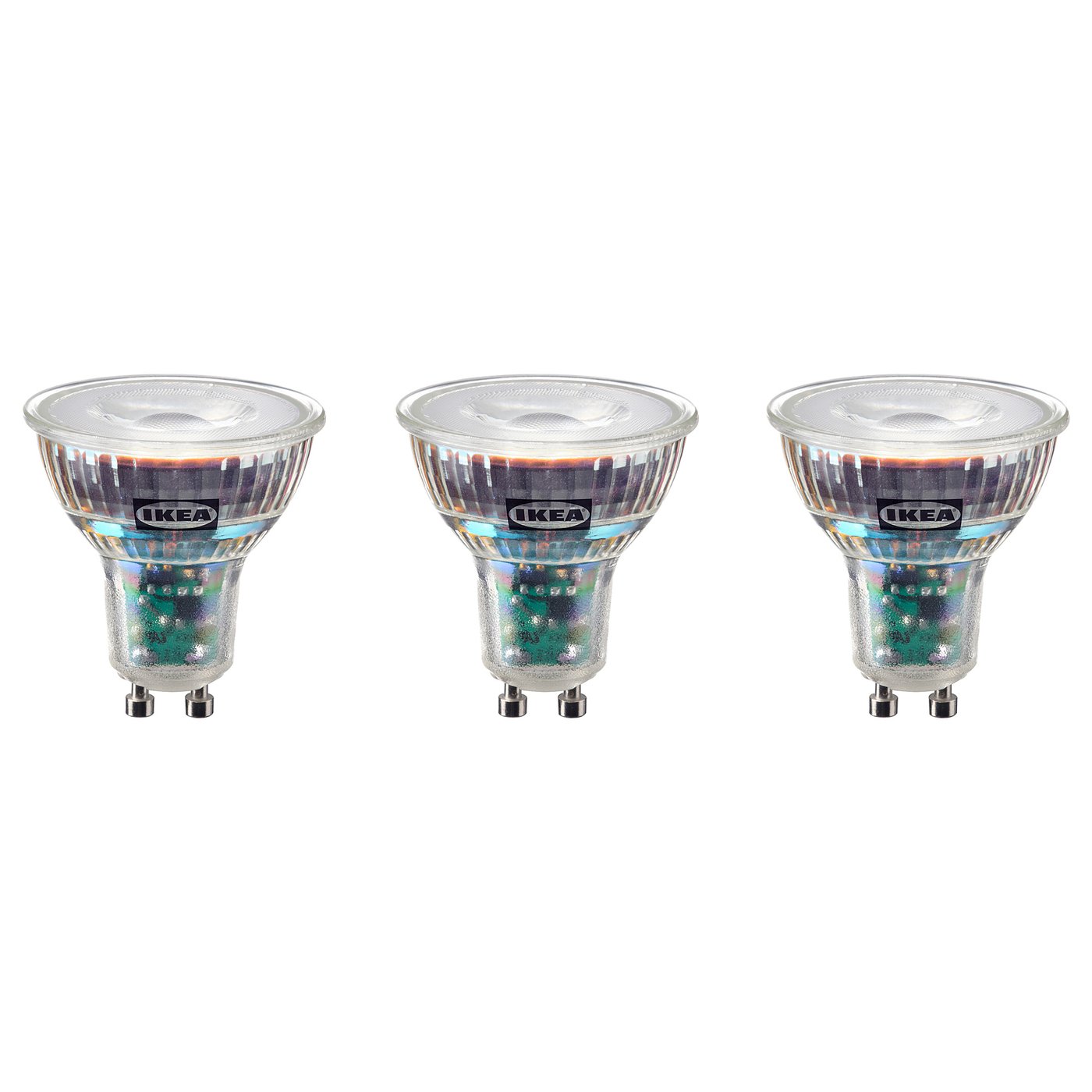 Three IKEA led bulbs in a row, warm-white light, transparent glass, copper base.