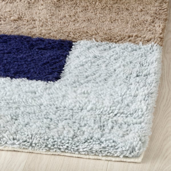 Plush multicoloured rug with soft texture and bold geometric design.