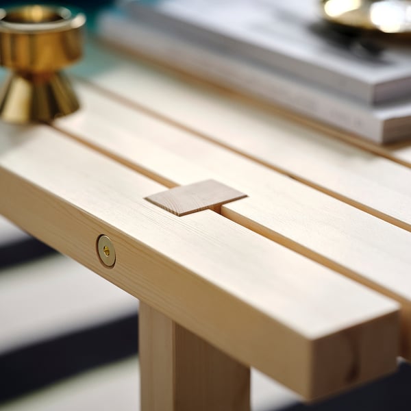 Wooden coffee table with natural finish. Visible joinery detail and gold-colored hardware.