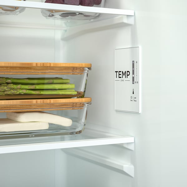 Clear fridge shelf shows temp control panel and organised veggies.