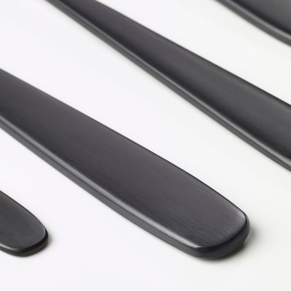 Close-up of sleek, matte black cutlery; smooth, polished edges.
