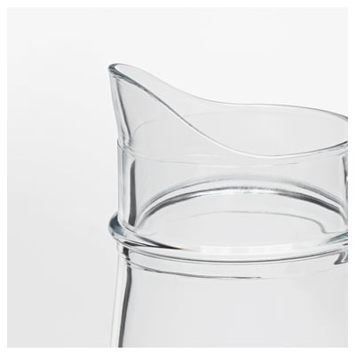 Clear glass jug with a curved handle, smooth surface, and wide mouth, ideal for serving beverages or as a vase.