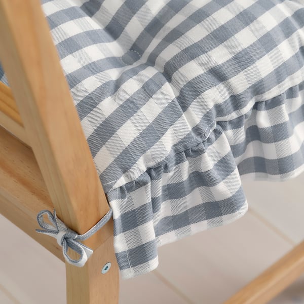 Chequered chair pad with frills and ties for comfort and decoration.