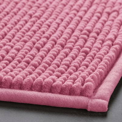 Close-up of soft pink bath mat, showcasing its textured surface and plush microfiber material.