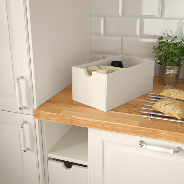 White wooden box on counter, storing kitchen items, removable for easy access.