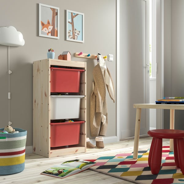 Kids play area with TROFAST storage, red boxes, wood, colourful rug. Low, bright, organised.