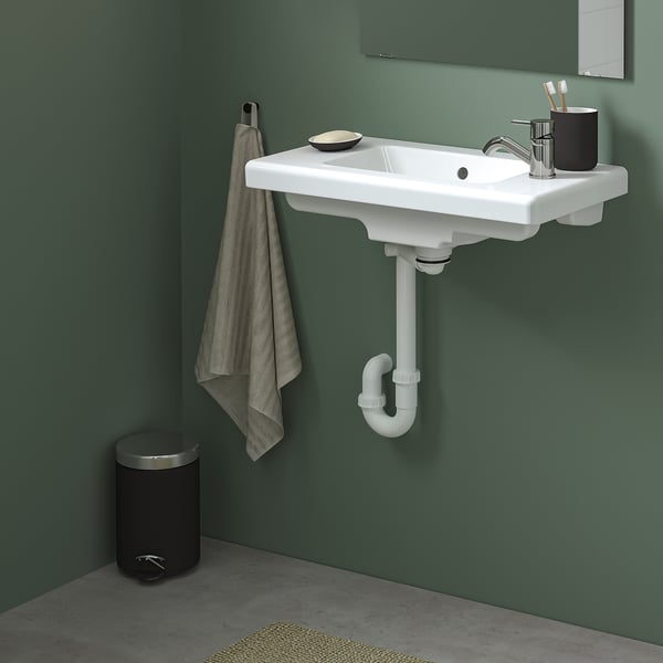 Modern bathroom with wall-mounted TVÄLLEN sink, green wall, simple design.