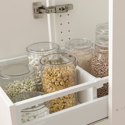 Kitchen drawer with adjustable dividers organising various food items in glass jars.