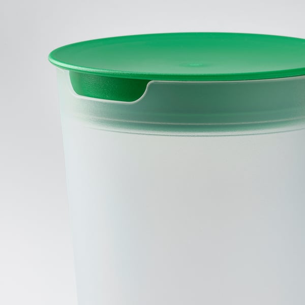 Green salad shaker lid with handle on white container.