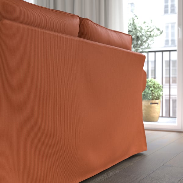 Bright orange UPPLAND sofa, deep cushions, near window and plants.