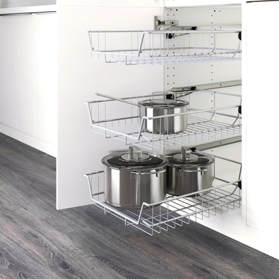 Kitchen cabinet with 3 wire pull-out baskets holding stainless pots and pans, promoting air circulation and easy visibility.