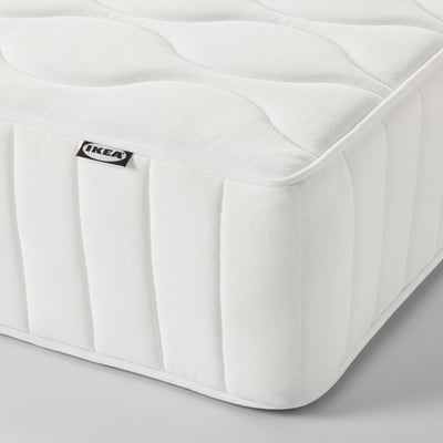 Close-up of IKEAs VÅGSTRANDA mattress, showcasing its textured, white surface with visible IKEA tag.