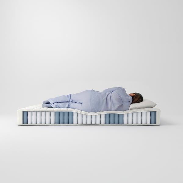 Person sleeping on blue, medium-firm, high VALEVÅG mattress with pocket springs and foam.