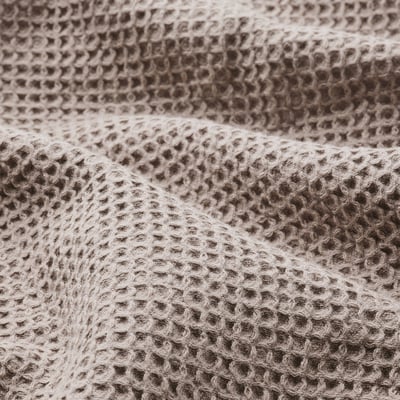 Close-up of waffle-textured towel in light grey and brown, soft and tightly woven.