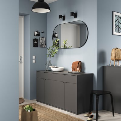 Modern hallway with grey VIHALS sideboard, mirror, pendant light, and wall decorations. Light blue walls, black accents, and a plant.