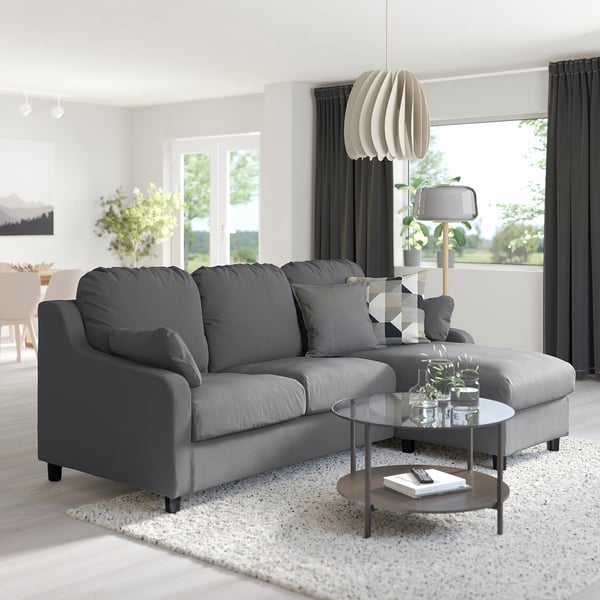 Modern living room with VINLIDEN sofa, glass coffee table, and lamps.