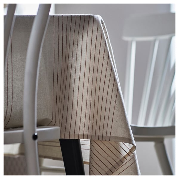 A beige and brown striped tablecloth made of cotton, elegantly draped over a table.