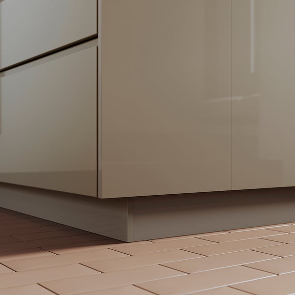 VOXTORP beige kitchen cabinet base, glossy finish, plastic material; fits tight to the tiled floor.